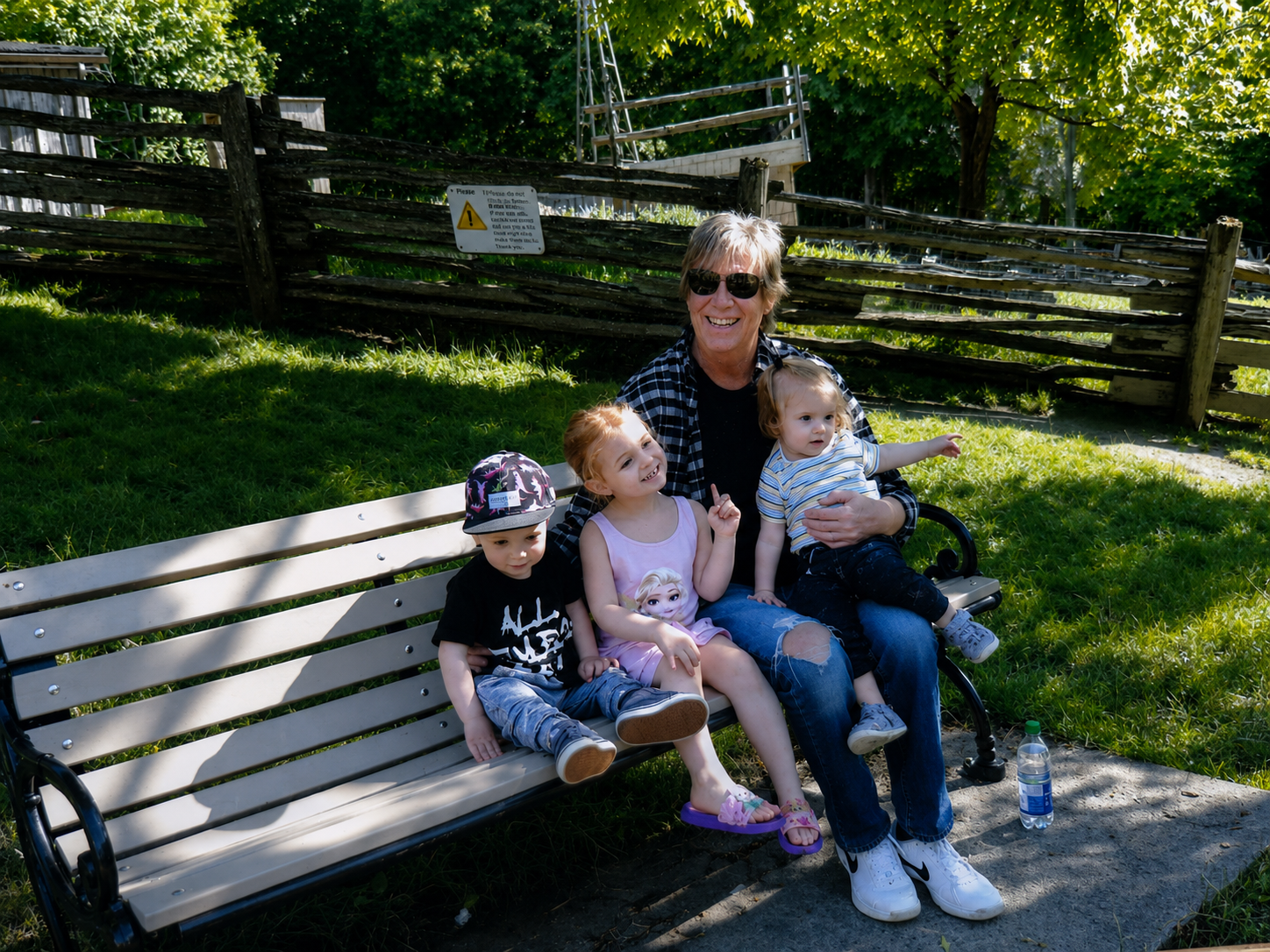 Dave on a park bench with three of his young grandchildren