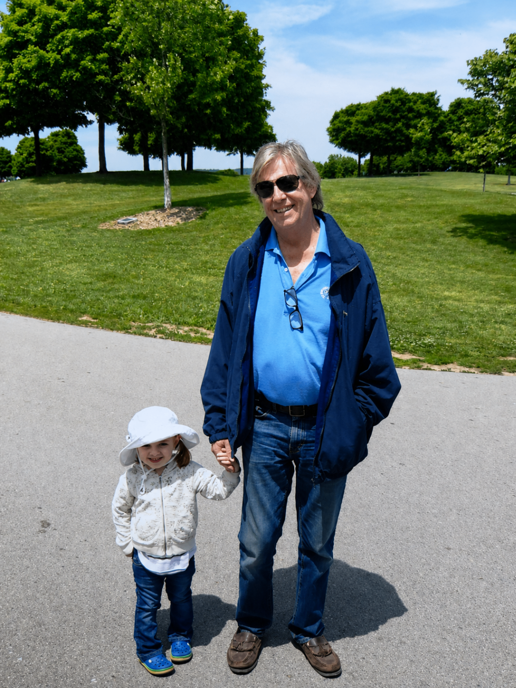 Dave walking hand in hand with his granddaughter in the sunshine